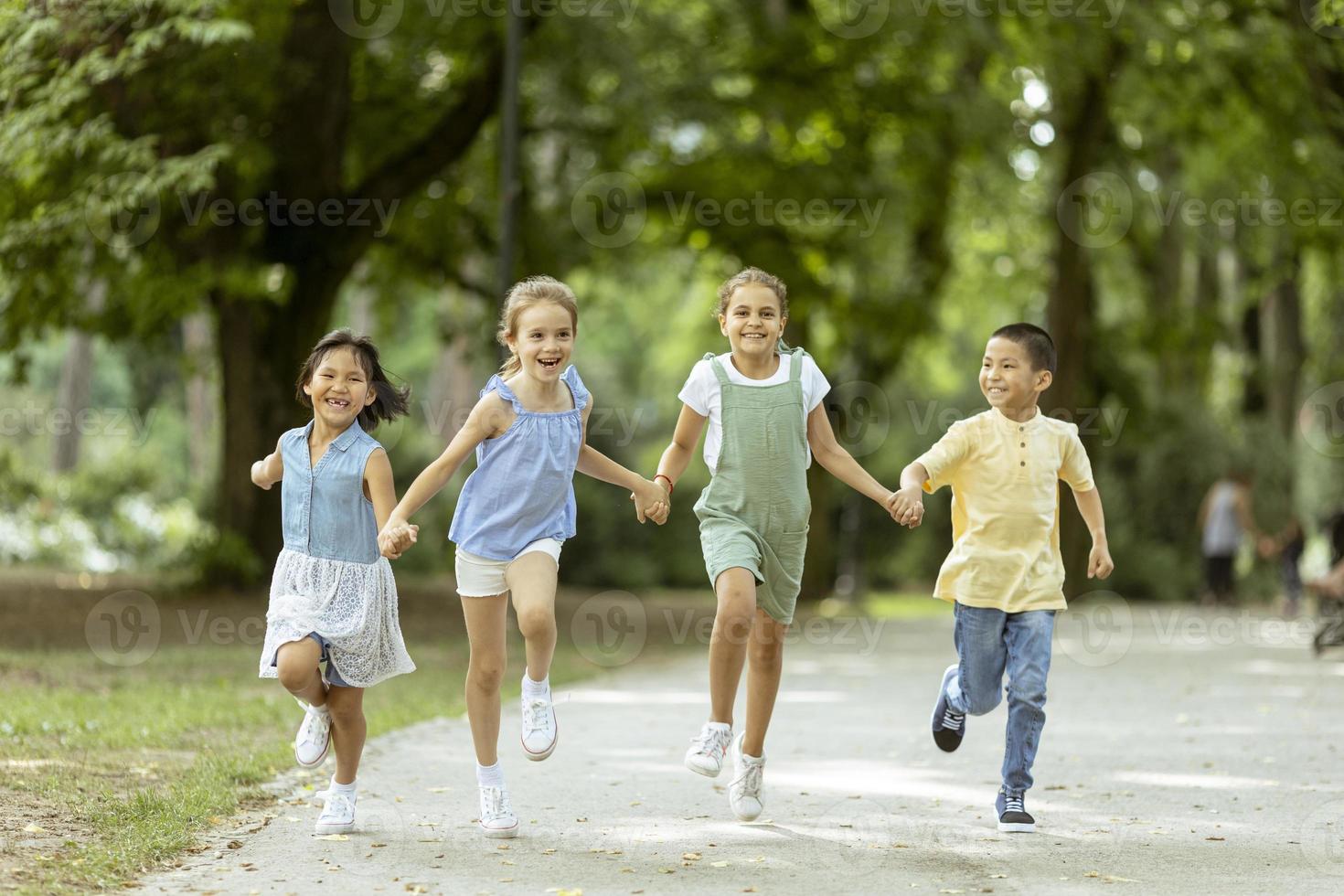 grupo de niños asiáticos y caucásicos divirtiéndose en el parque foto