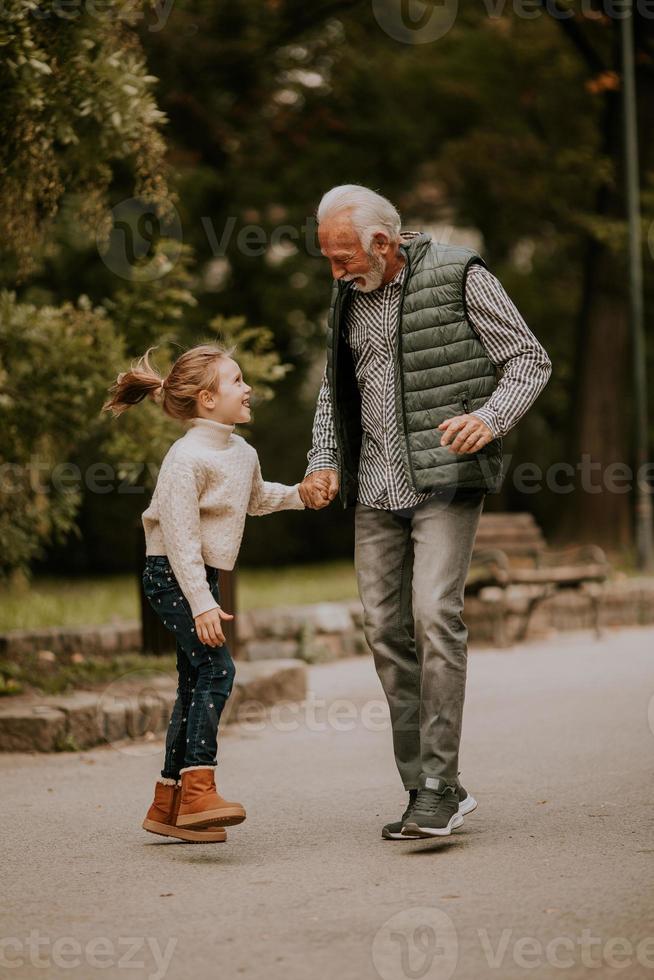 abuelo pasando tiempo con su nieta en el parque el día de otoño foto