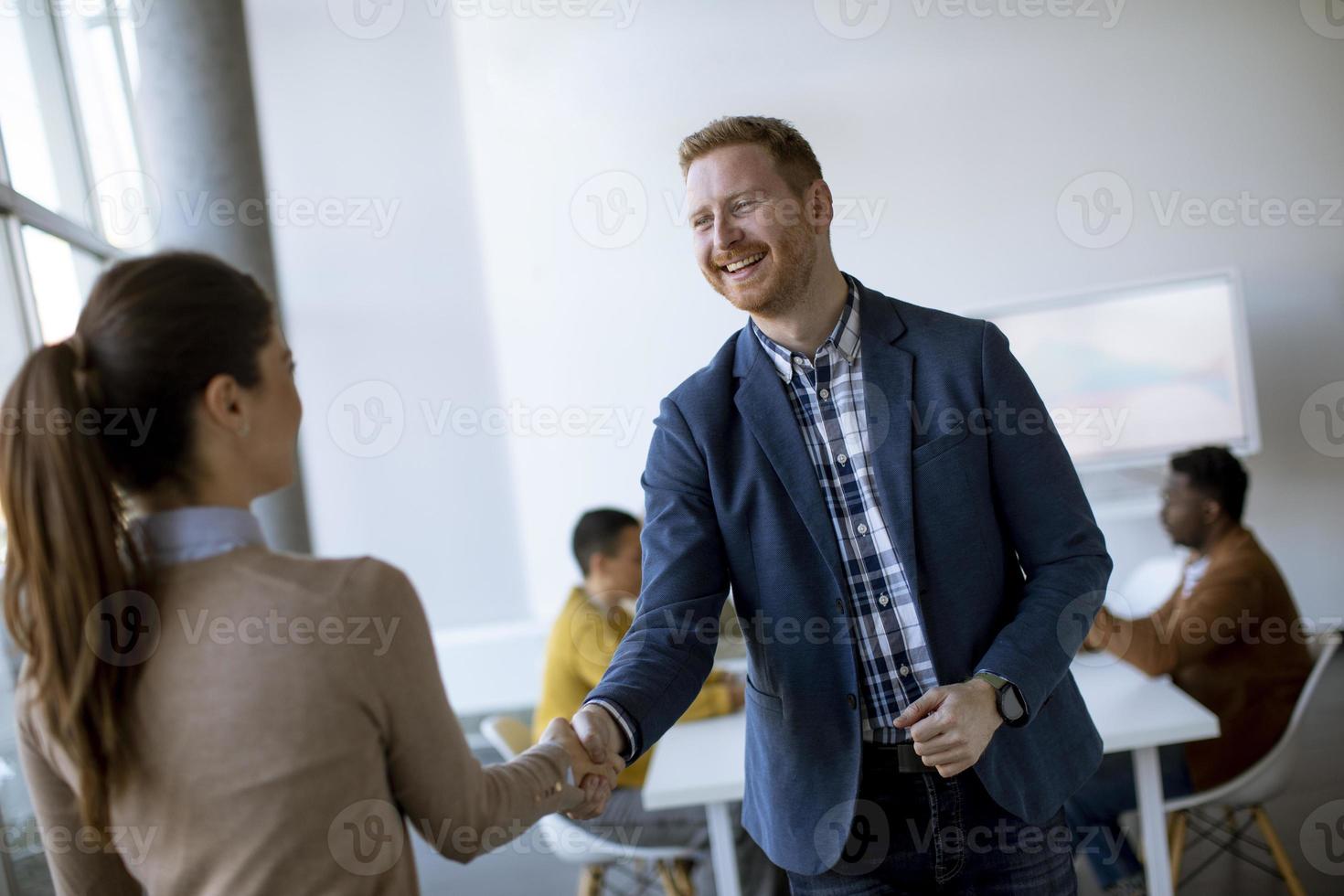 Young business partners making handshake in an office photo
