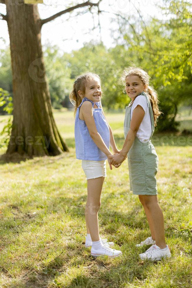 dos niñas cogidas de la mano en el parque foto