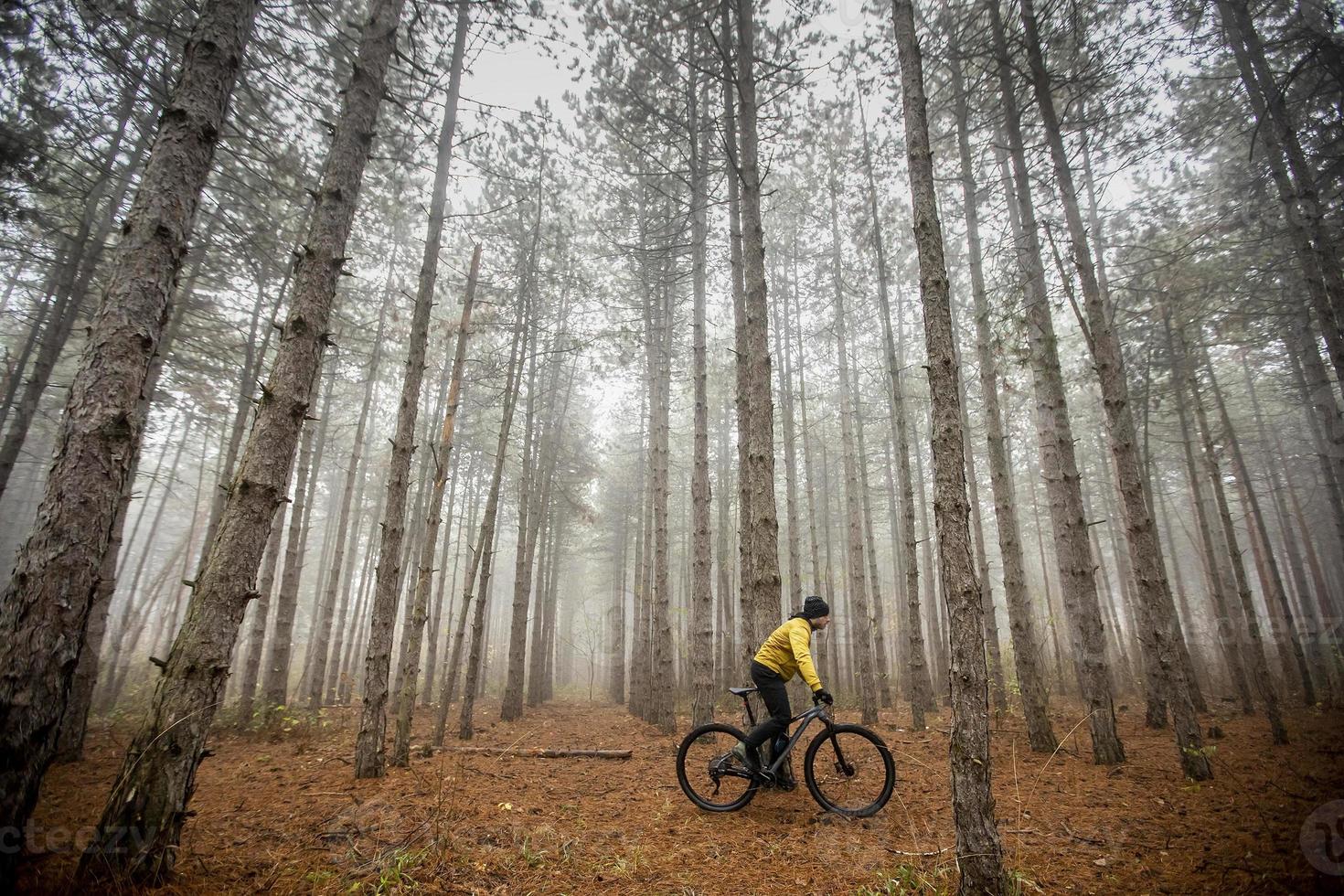 joven en bicicleta por el bosque de otoño foto