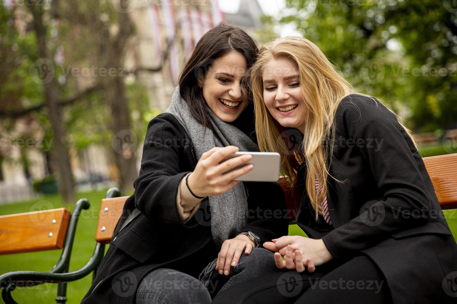 Young female tourists taking selfie with mobile photo in centre of Vienna, Austria