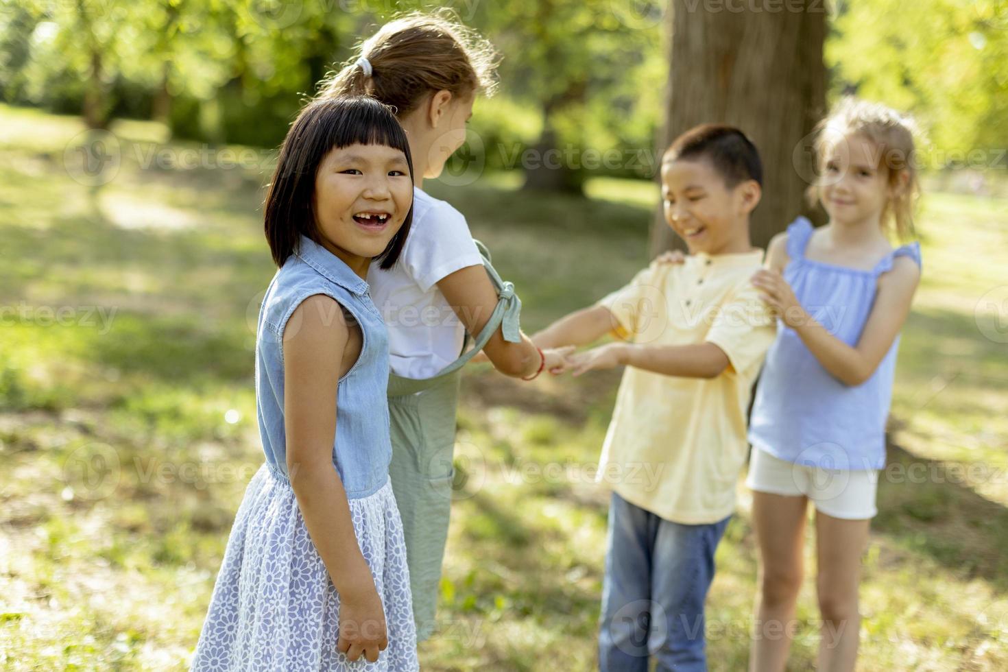Group of asian and caucasian kids having fun in the park photo