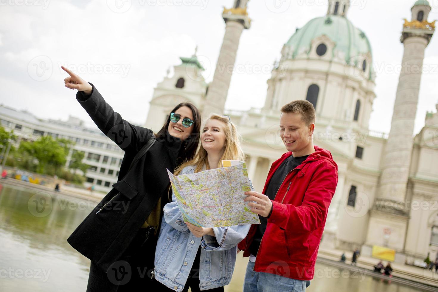 jóvenes turistas mirando el mapa callejero de viena, austria foto