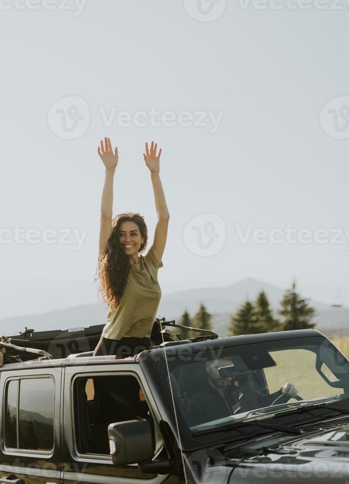 Young woman enjoying freedom in terrain vehicle on a sunny day photo