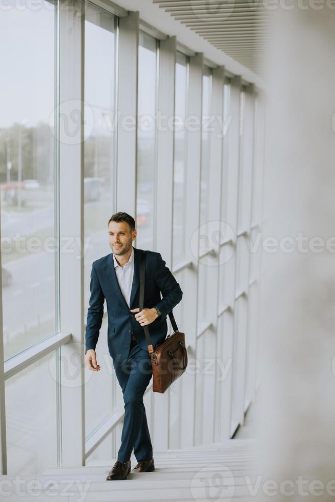 Young business executive with briefcase going up the stairs photo