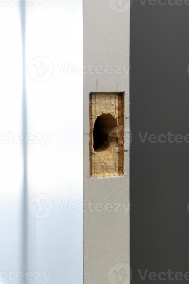Edge of white door with a hole for the lock photo