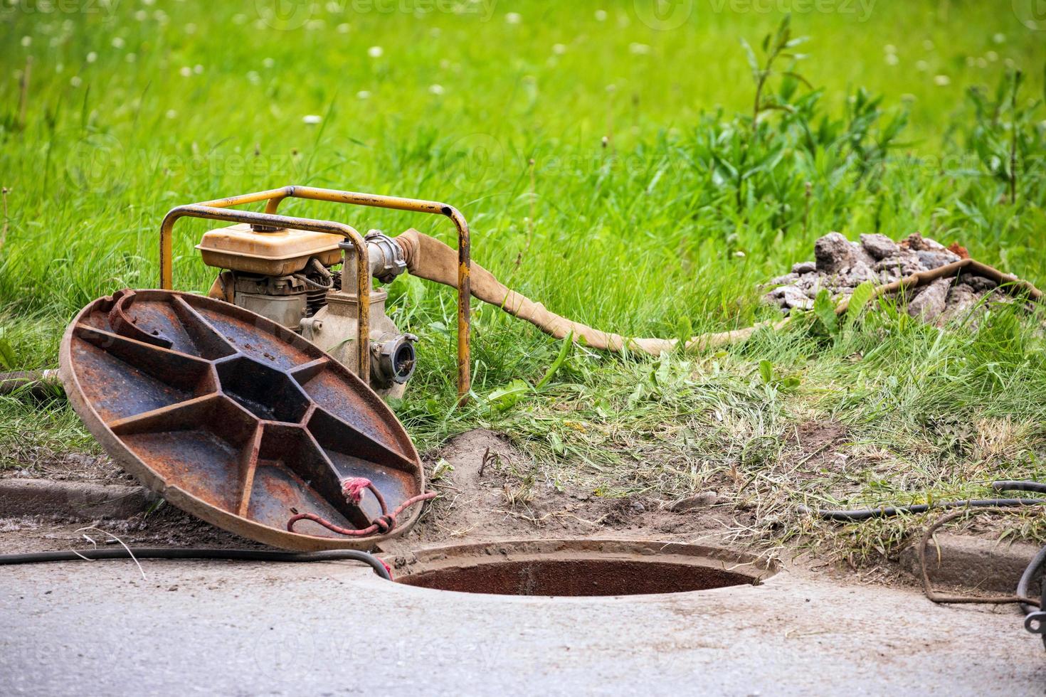 Plumber's tools near opened manhole photo