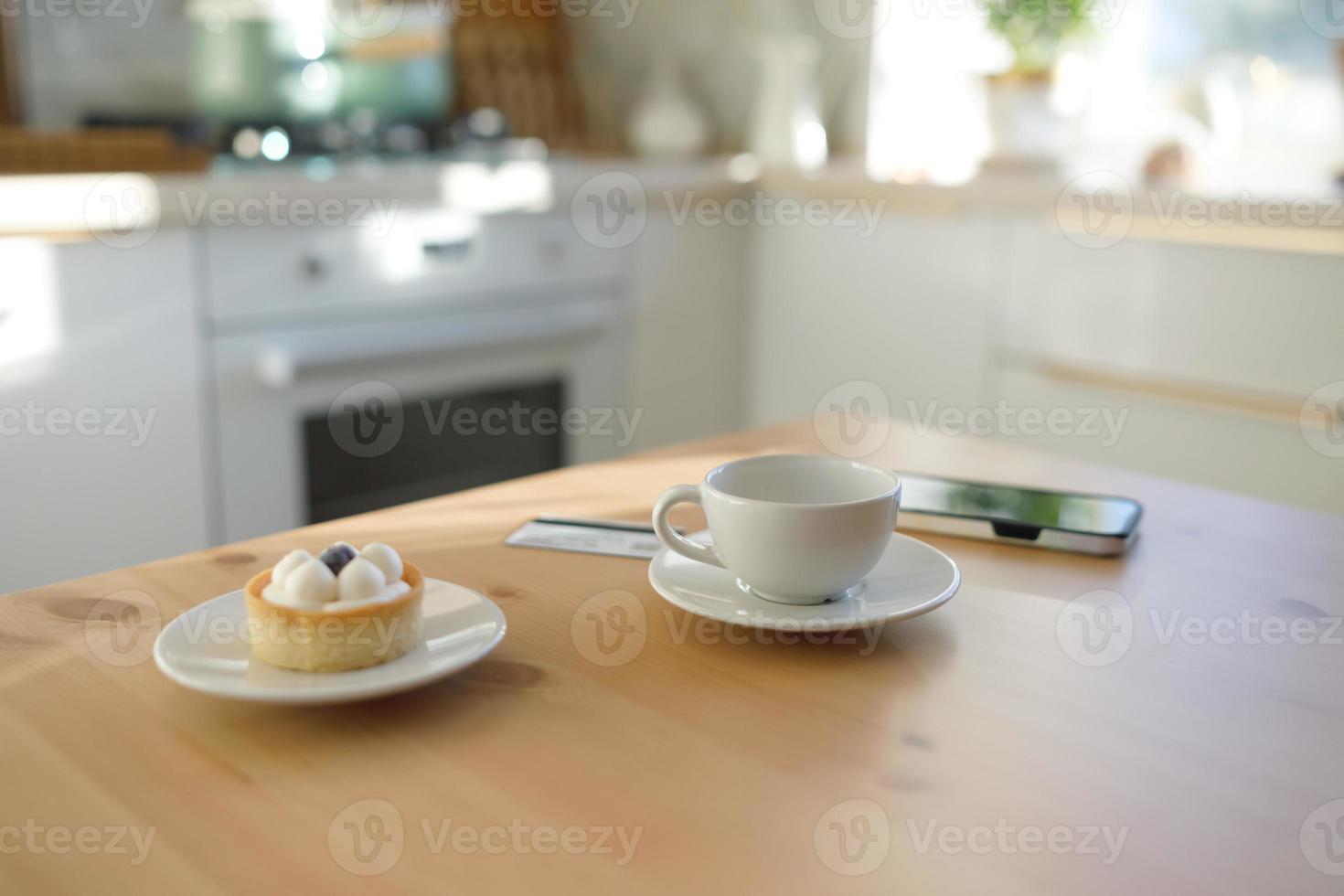 Kitchen table, credit card, cup of coffee or tea and smartphone photo