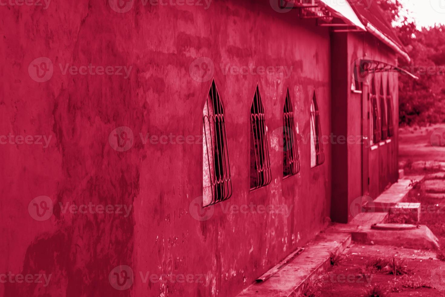 Beautiful red wall of the building. Red building with unusual Windows. photo