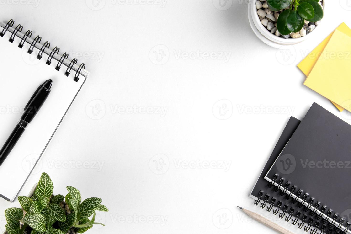 vista superior del escritorio de oficina blanco moderno con teclado de computadora, página de cuaderno en blanco y otros equipos sobre fondo blanco. concepto de espacio de trabajo, estilo de gestión del espacio de trabajo, espacio de diseño empresarial con copia foto