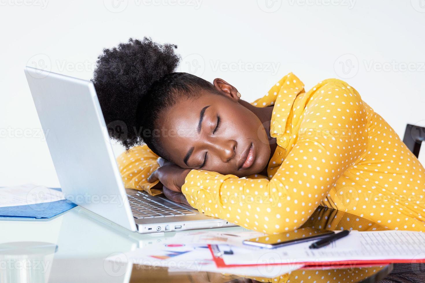Tired overworked woman resting while she was working writing notes. Overworked and tired businesswoman sleeping over a laptop in a desk at home. Tired businesswoman photo