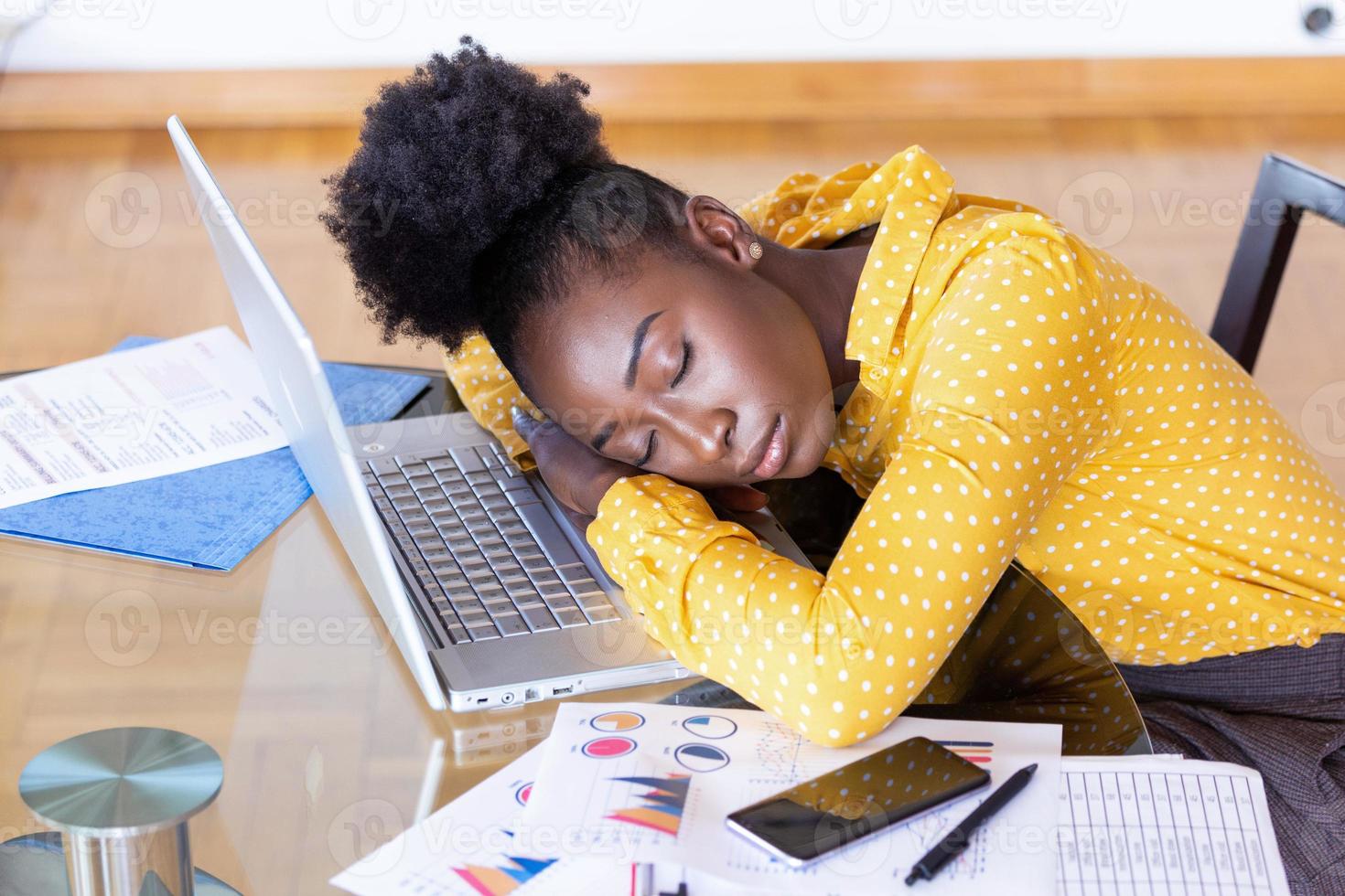 Tired overworked woman resting while she was working writing notes. Overworked and tired businesswoman sleeping over a laptop in a desk at home. Tired businesswoman photo