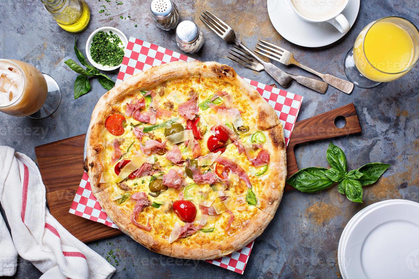 Breakfast pizza with scrambled egg, ham and tomatoes photo