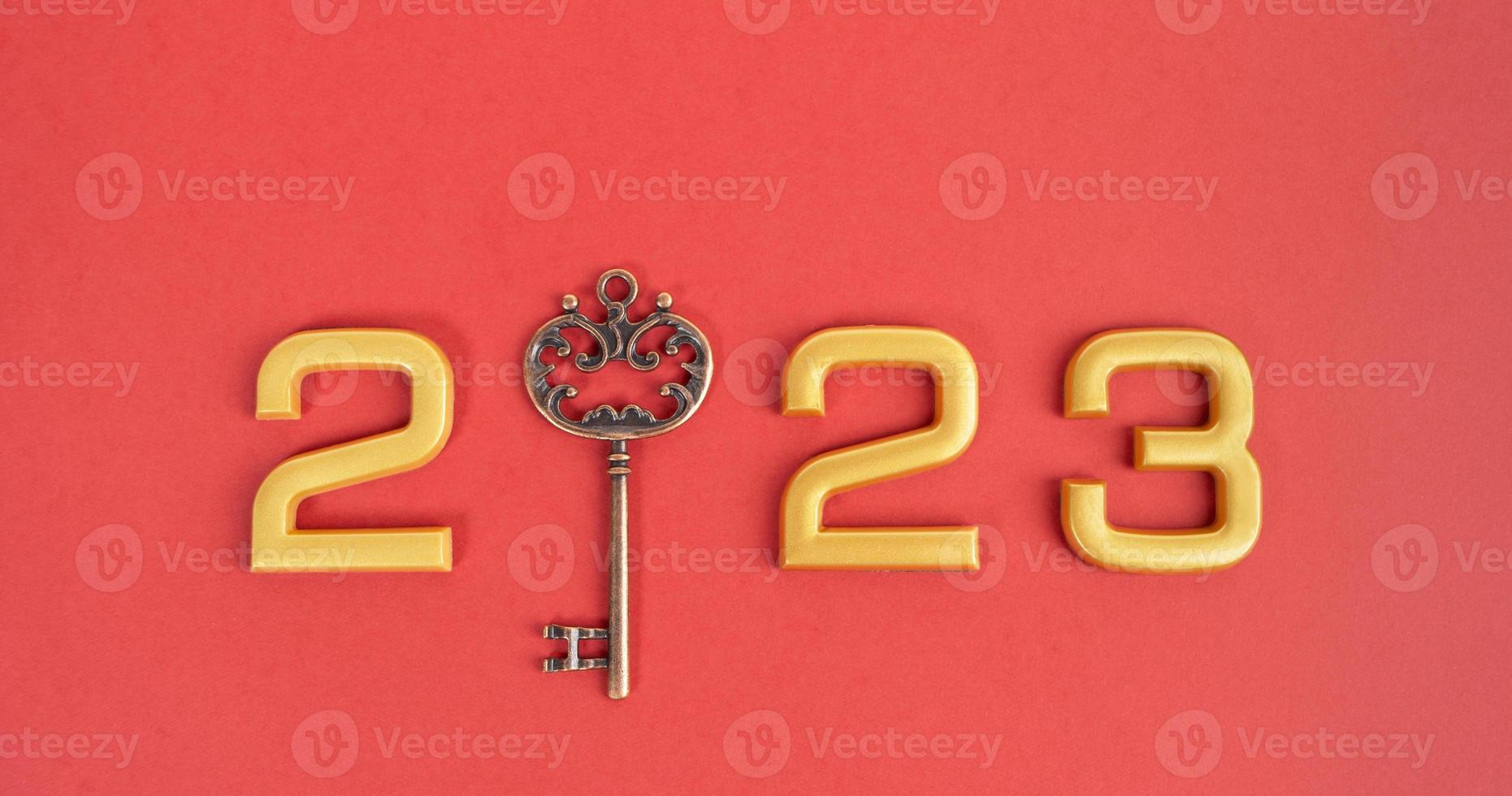 Number 2023 with key on red background. Happy New Year and Christmas 2023 concept. photo