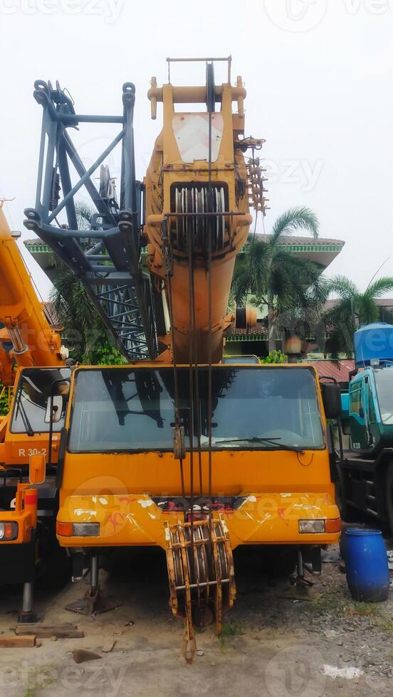 Front view old yellow telescopic mobile crane parking at the yard. photo