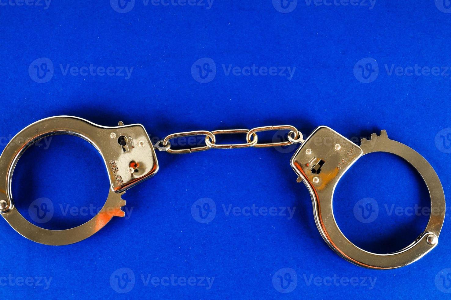 Handcuffs on blue background photo