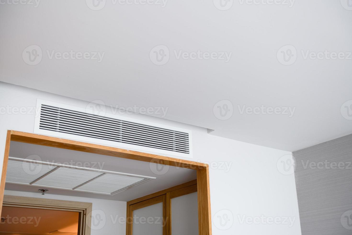 Ceiling mounted cassette type air conditioner and modern lamp light on white ceiling. duct air conditioner for home or office photo