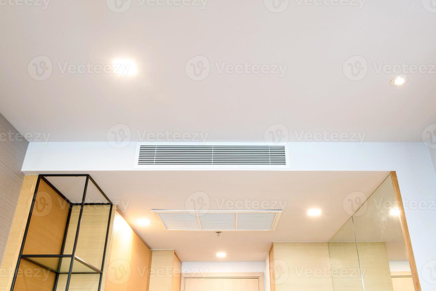 Ceiling mounted cassette type air conditioner and modern lamp light on white ceiling. duct air conditioner for home or office photo