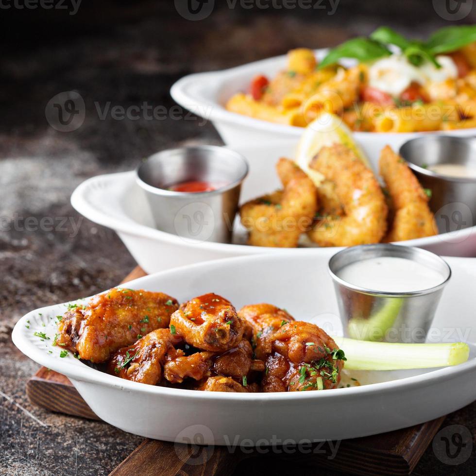 Variety of appetizers with fried shrimp and wings photo