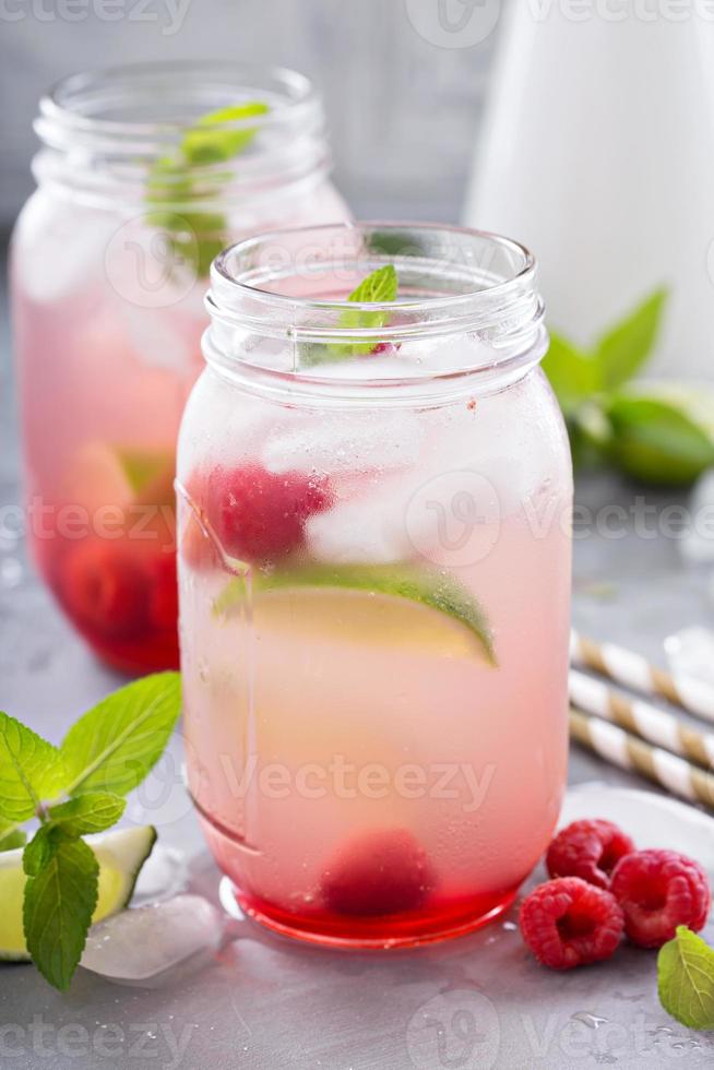 Cold green iced tea with lime and raspberry photo