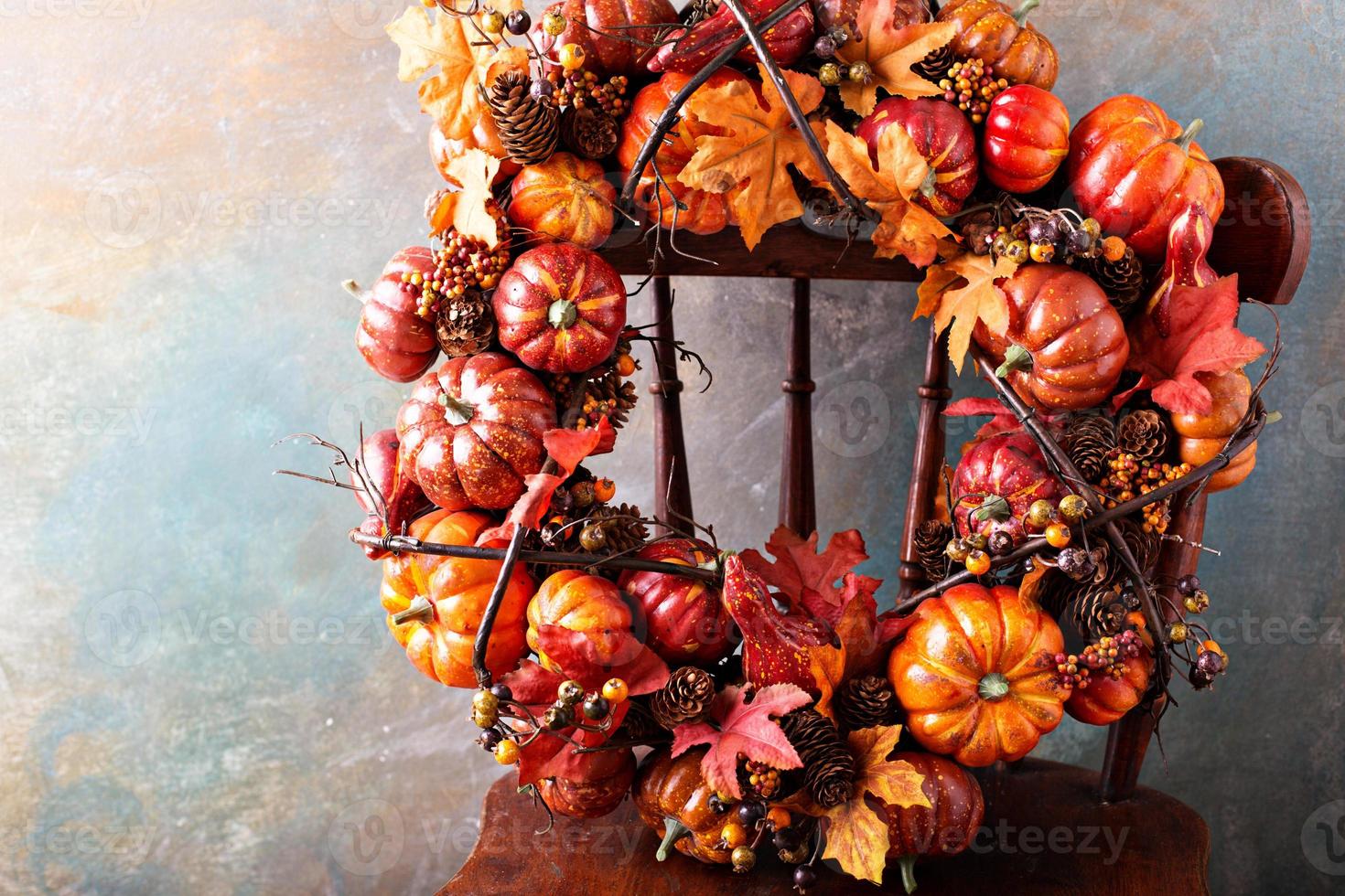 Festive autumn wreath with pumpkin and fall leaves photo