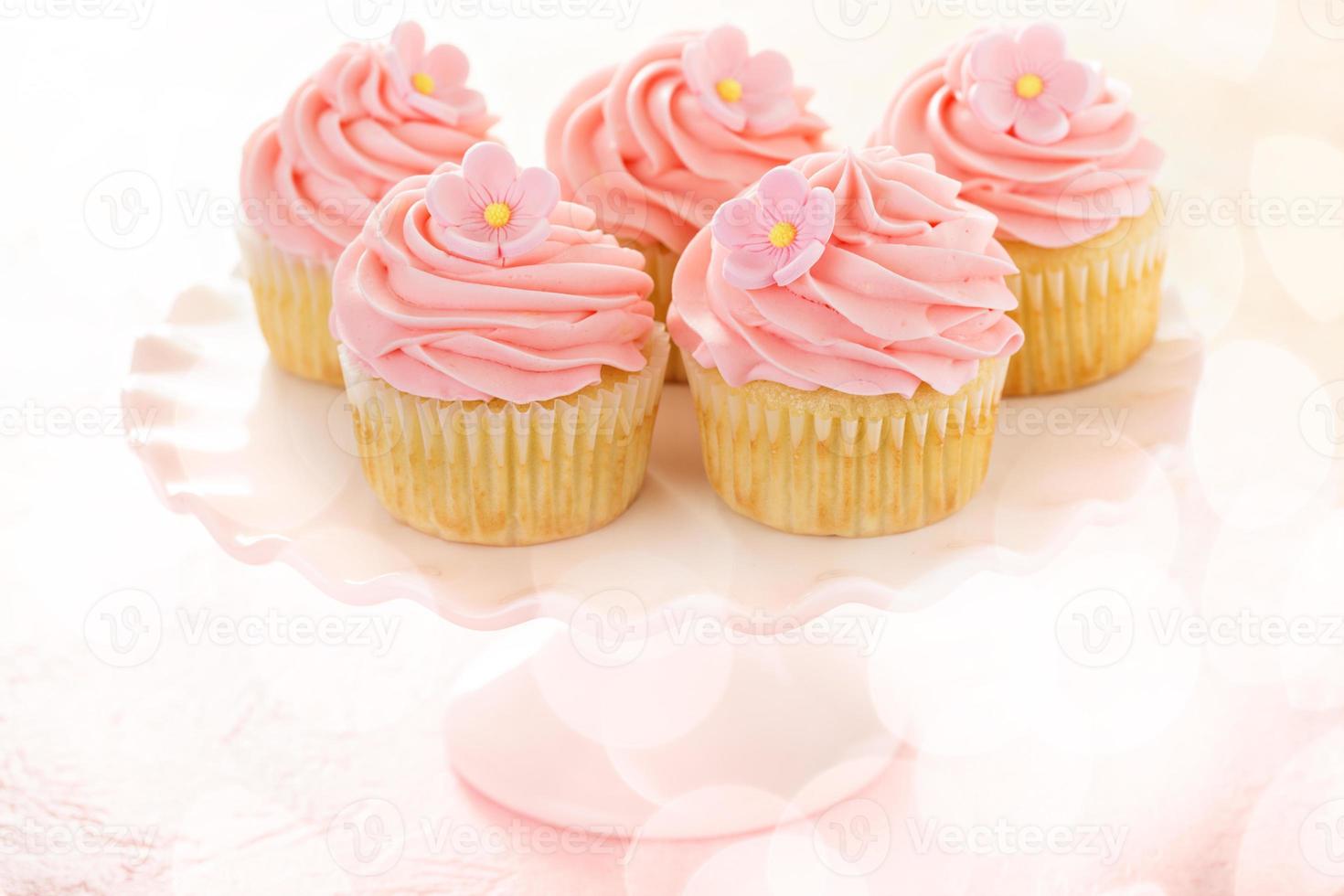 Vanilla cupcakes with pink raspberry frosting photo