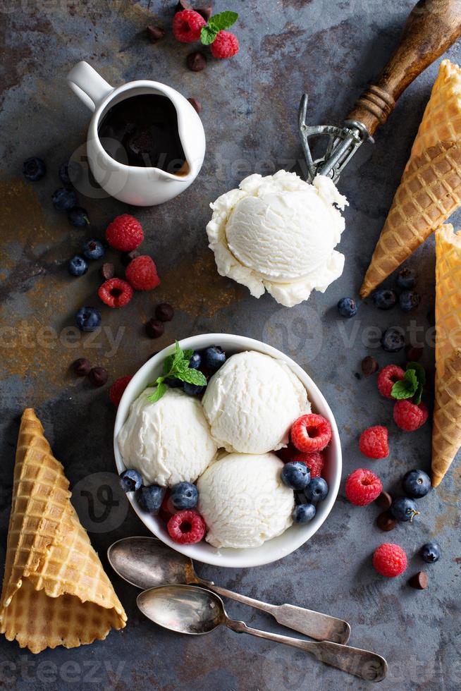 Vanilla ice cream scoops in a bowl with fresh berries photo