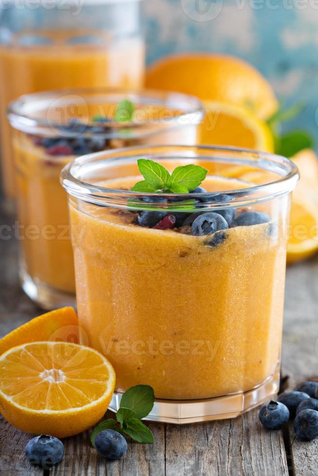 Orange and mango smoothie with granola photo