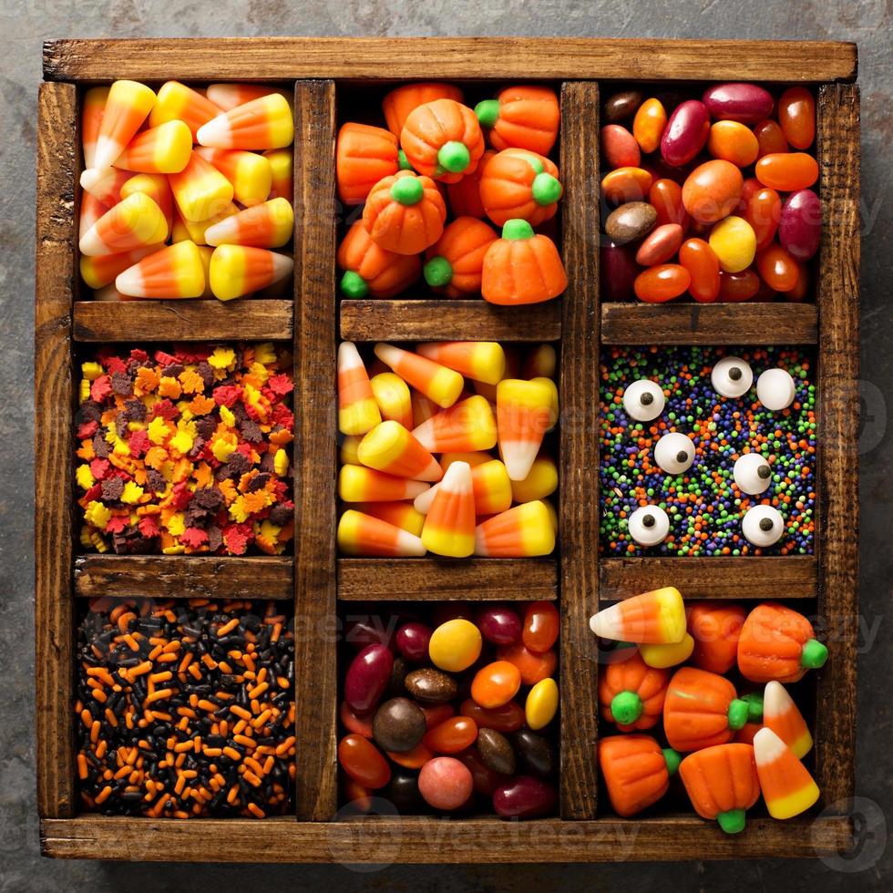 Halloween candy and sprinkles in wooden box photo