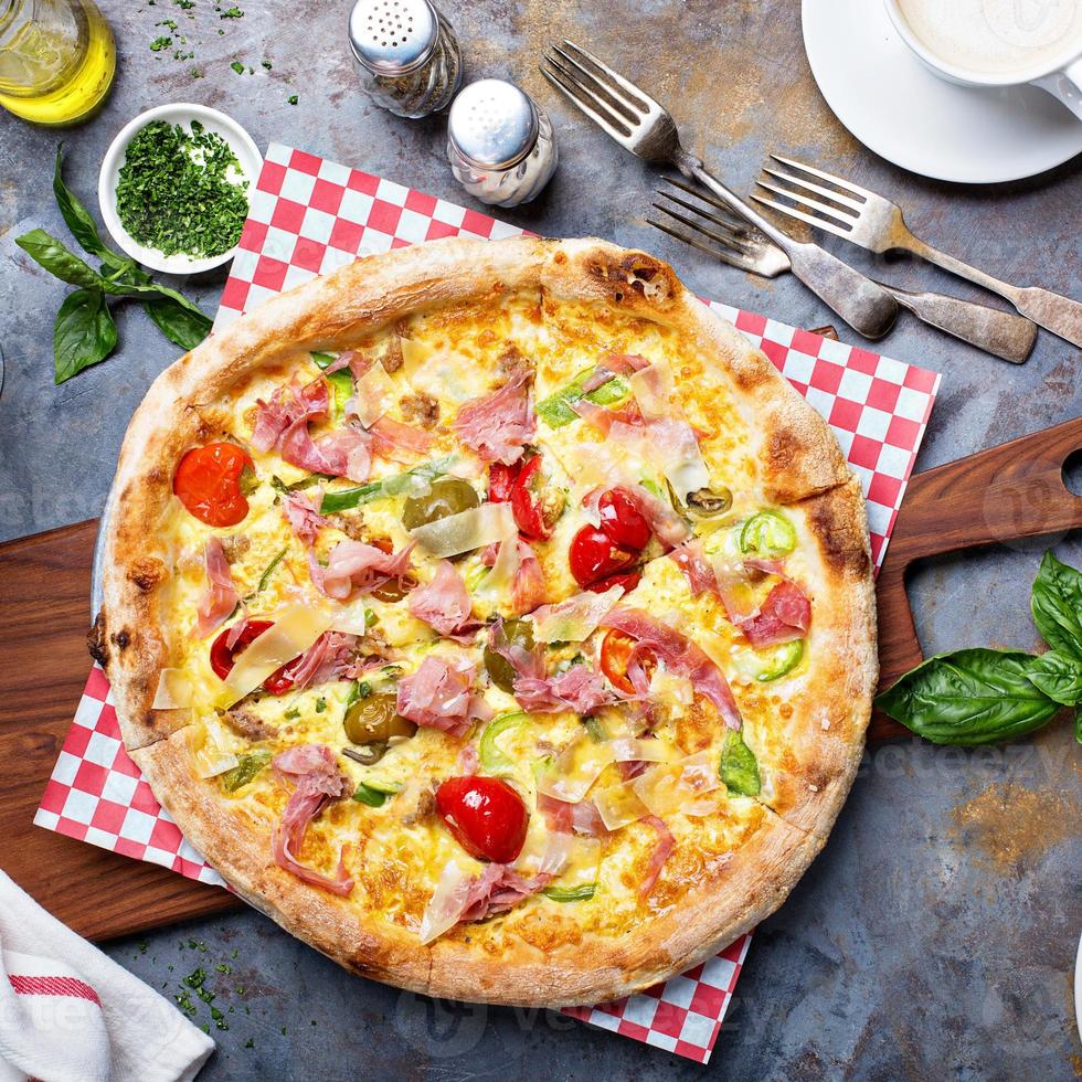 Breakfast pizza with scrambled egg, ham and tomatoes photo