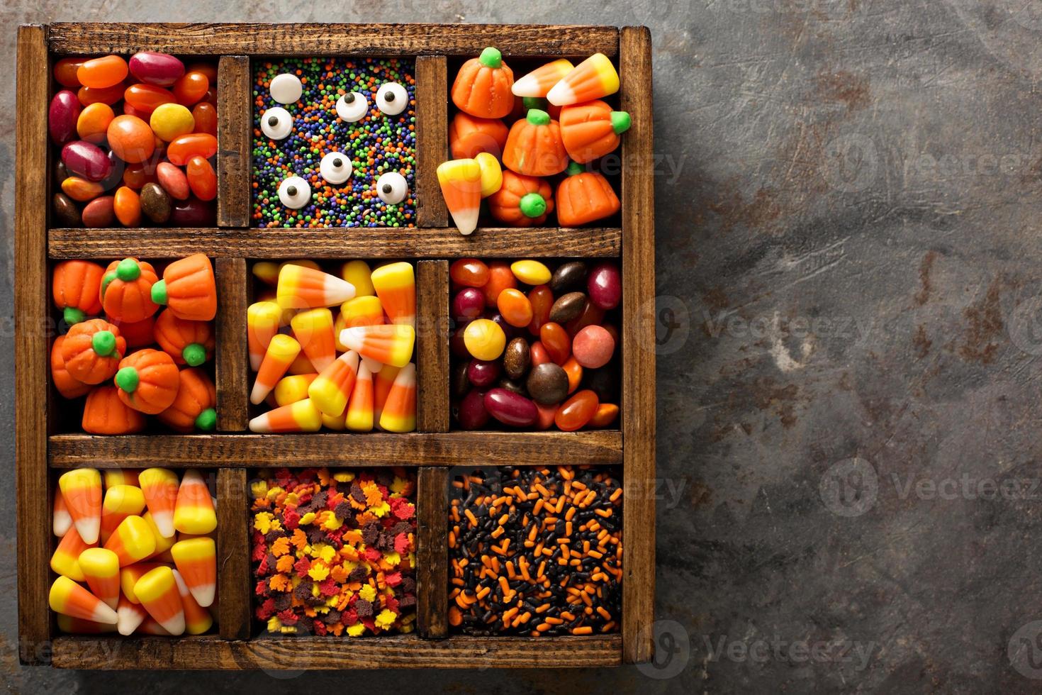 Halloween candy and sprinkles in wooden box photo