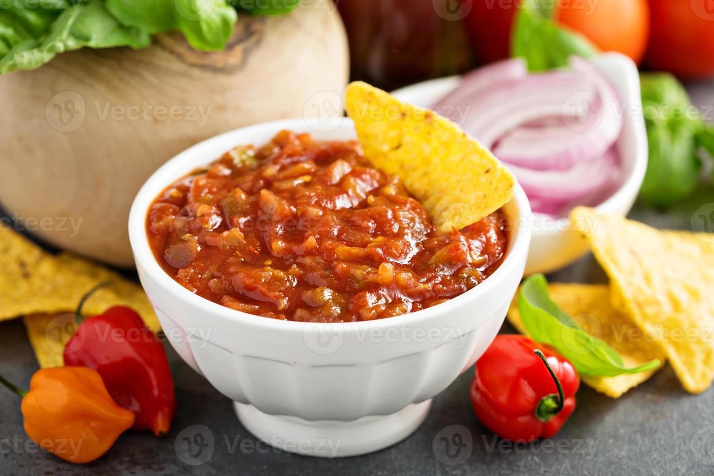 Red tomato spicy salsa with chips photo