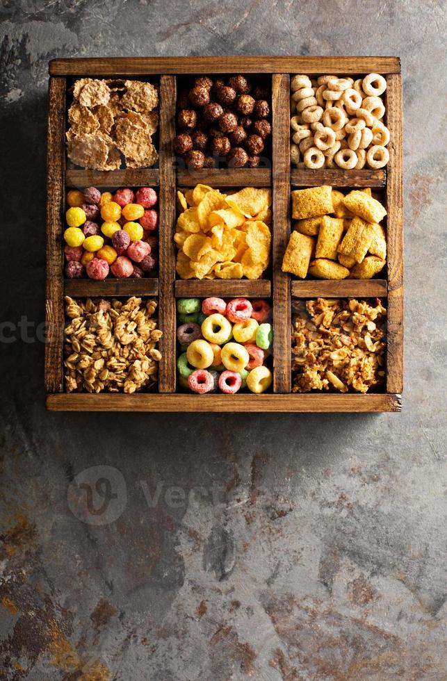 Variety of cold cereals in a wooden box overhead photo