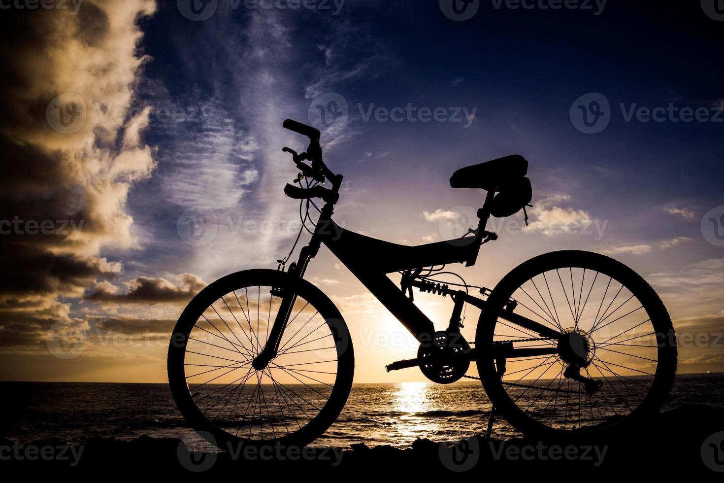 Bycicle silhouette by the ocean photo