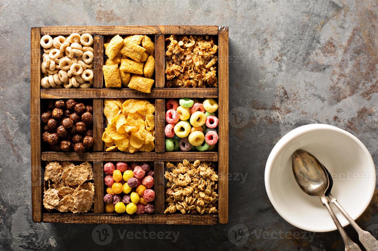 Variety of cold cereals in a wooden box overhead photo