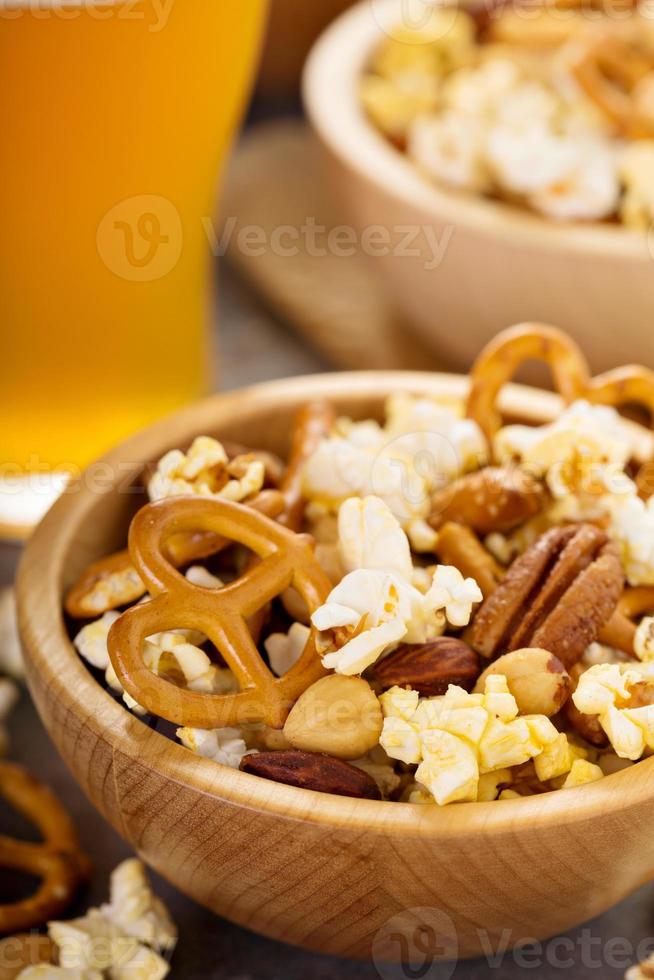 Homemade trail or snack mix with popcorn, pretzels and nuts with beer
