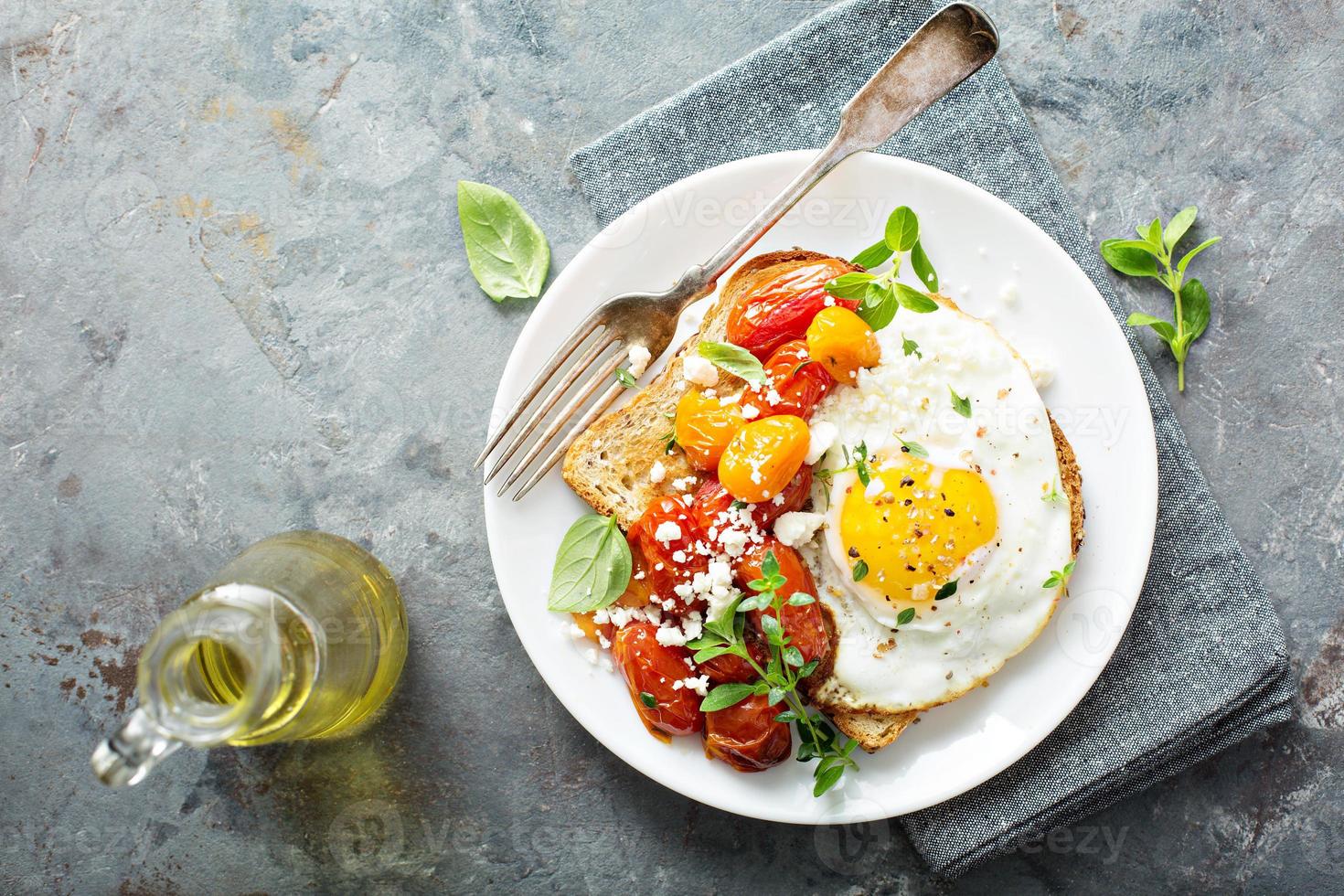 Multigrain toast with fried egg and roasted tomatoes photo