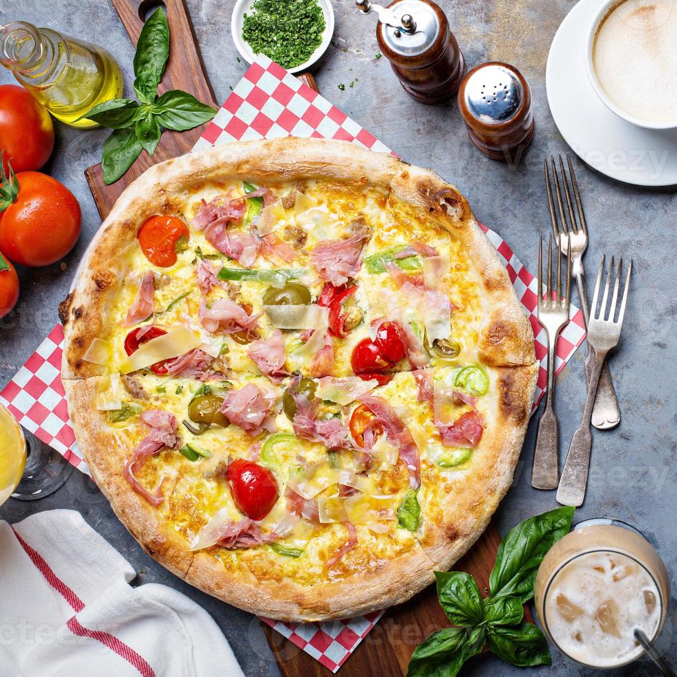 Breakfast pizza with scrambled egg, ham and tomatoes photo