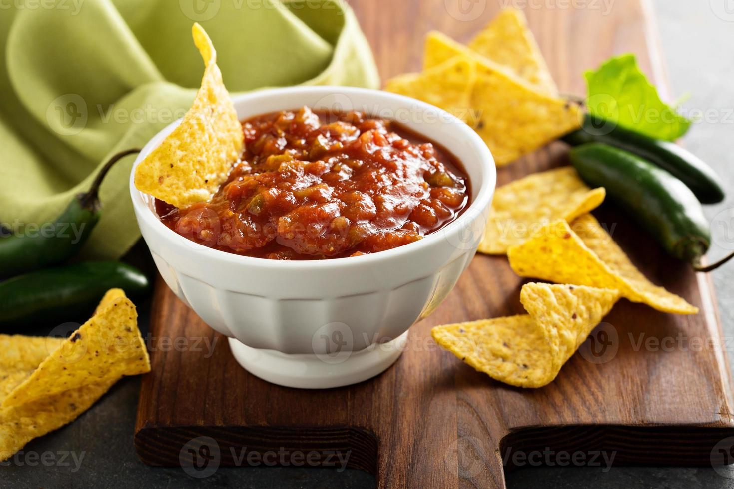 Red tomato spicy salsa with chips photo
