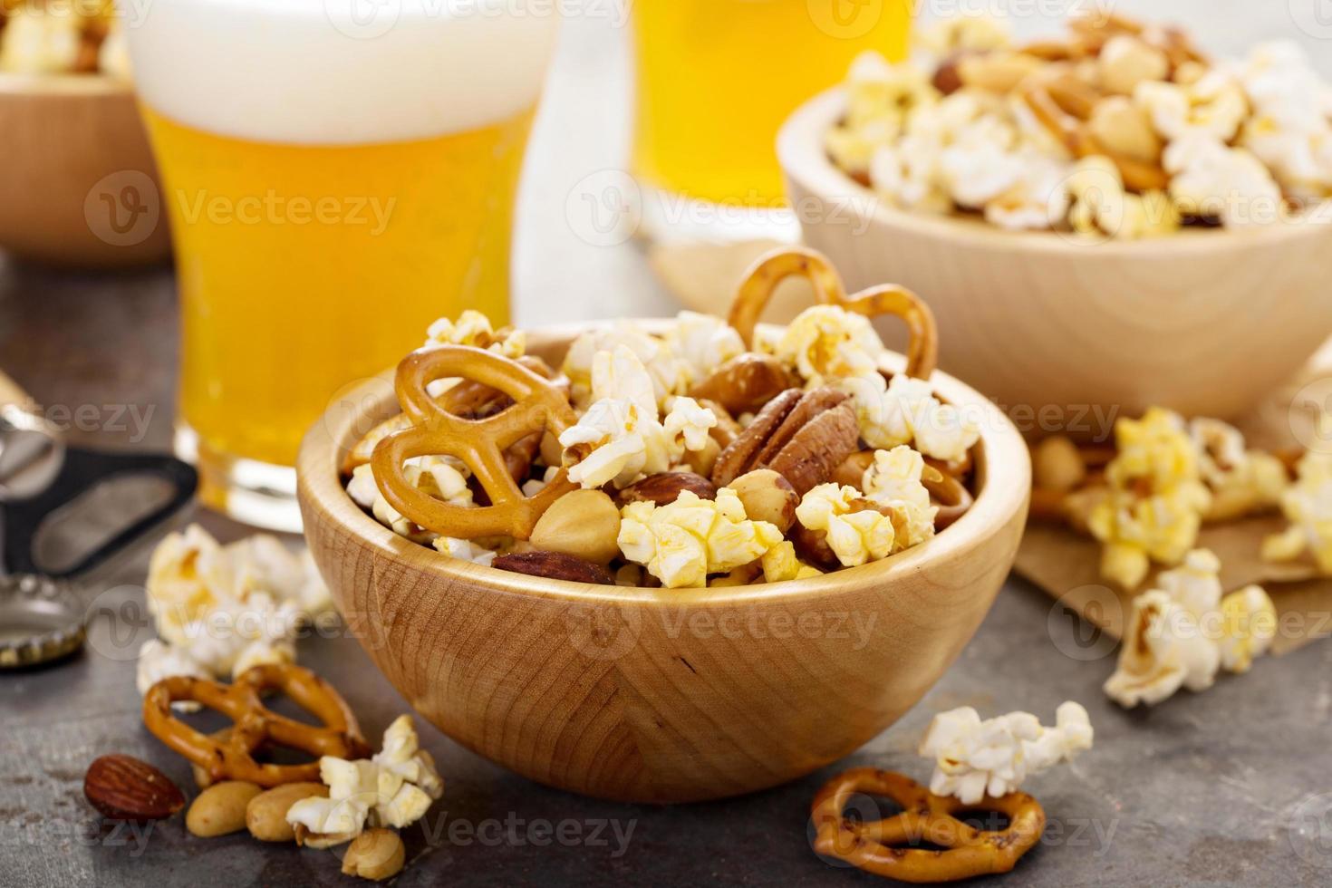 Homemade trail or snack mix with popcorn, pretzels and nuts with beer photo