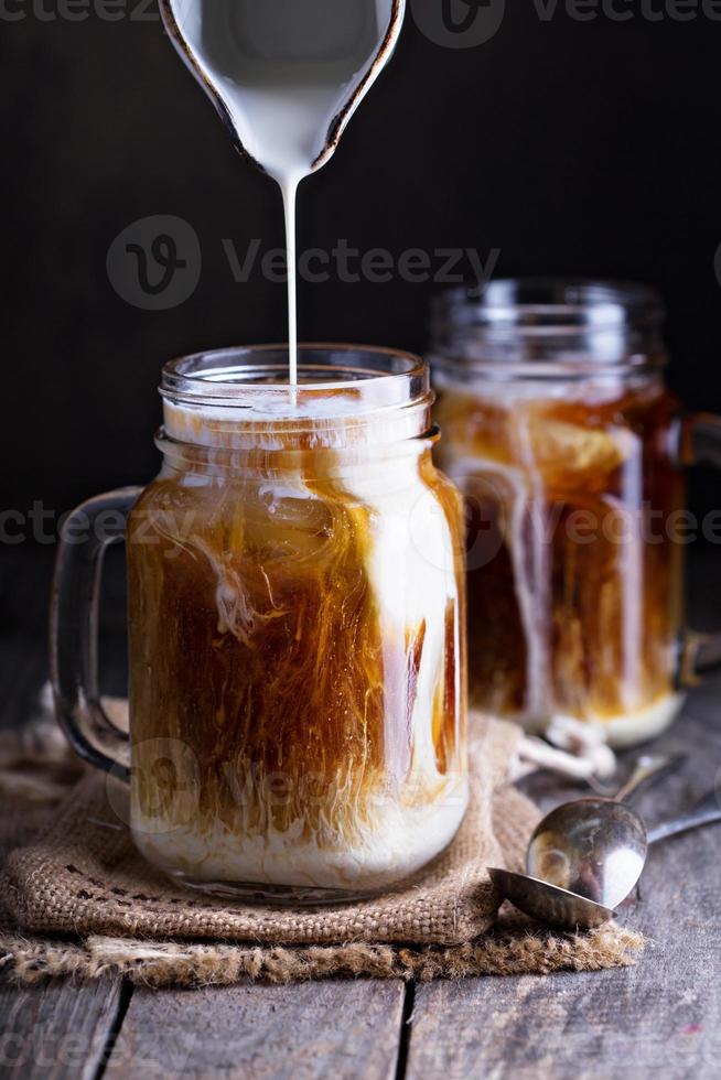 Iced coffee with milk in mason jars photo