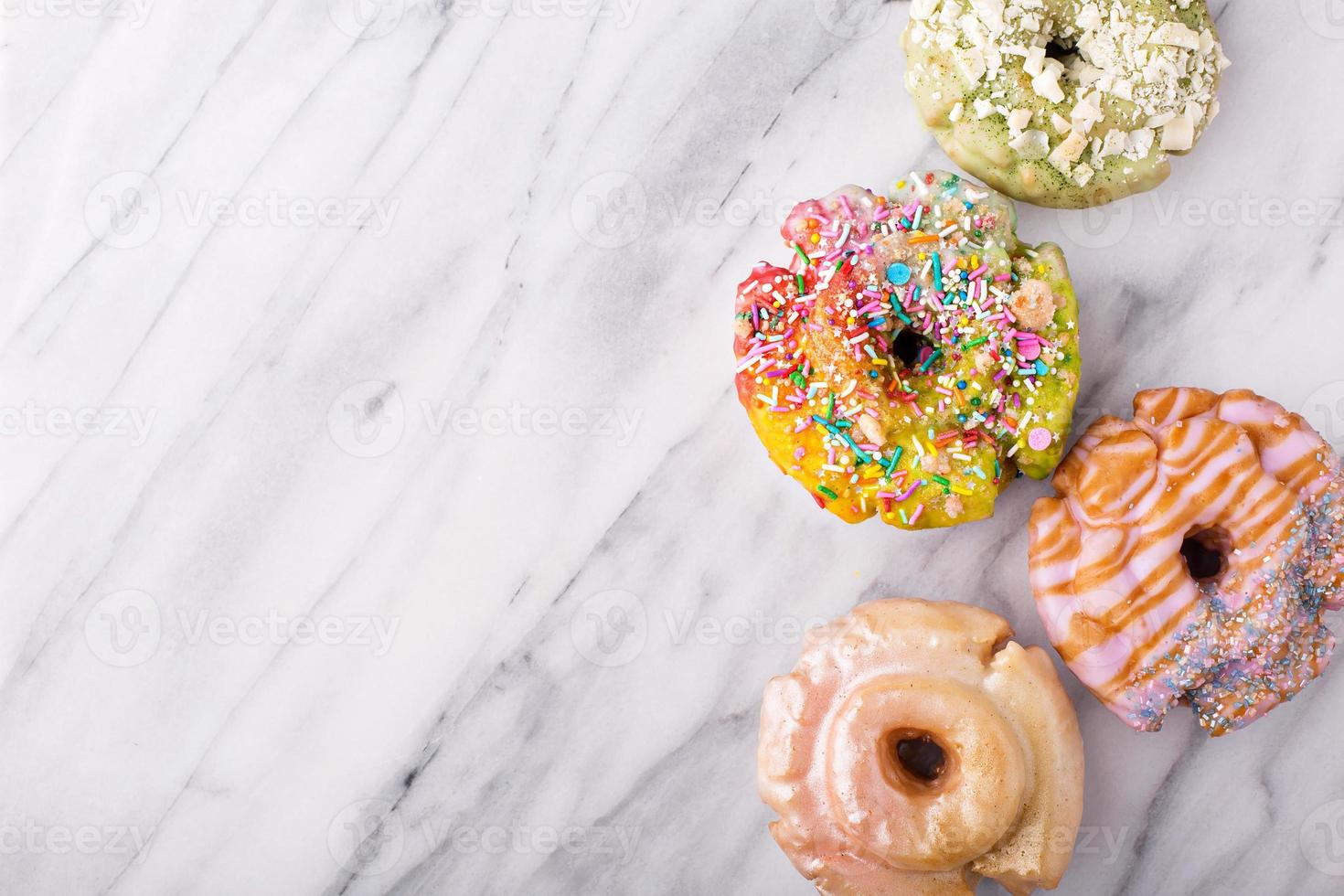 Variety of donuts on a marble surface photo