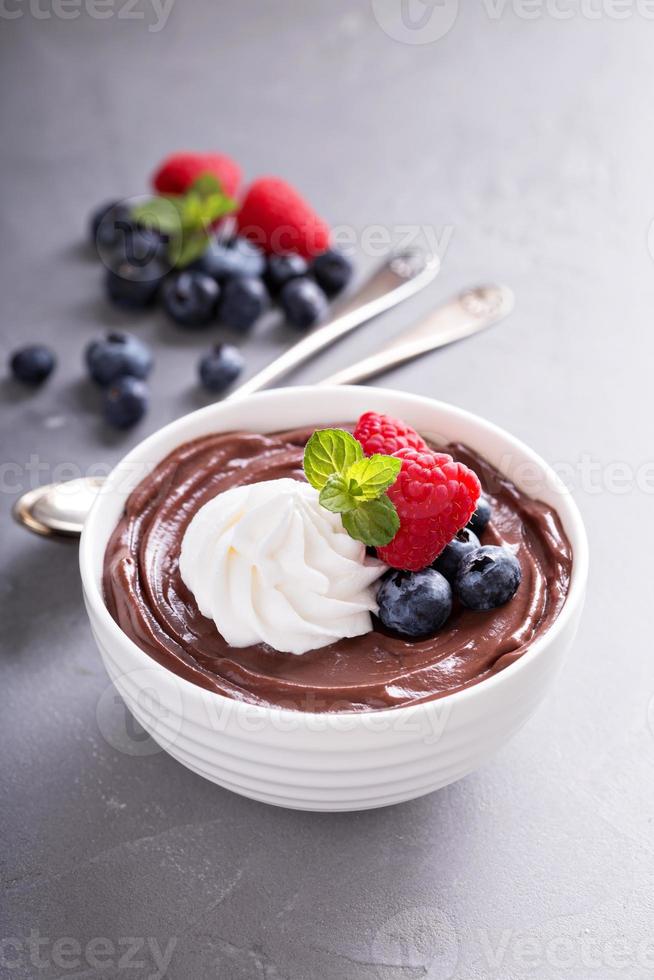 Chocolate pudding with whipped cream and berries photo