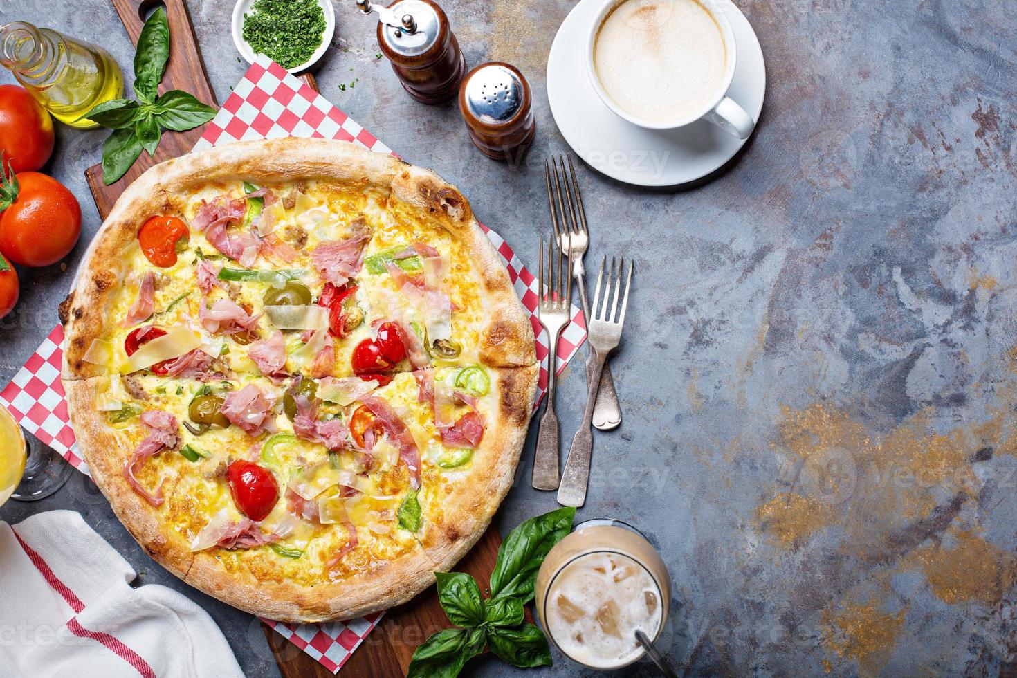 Breakfast pizza with scrambled egg, ham and tomatoes photo