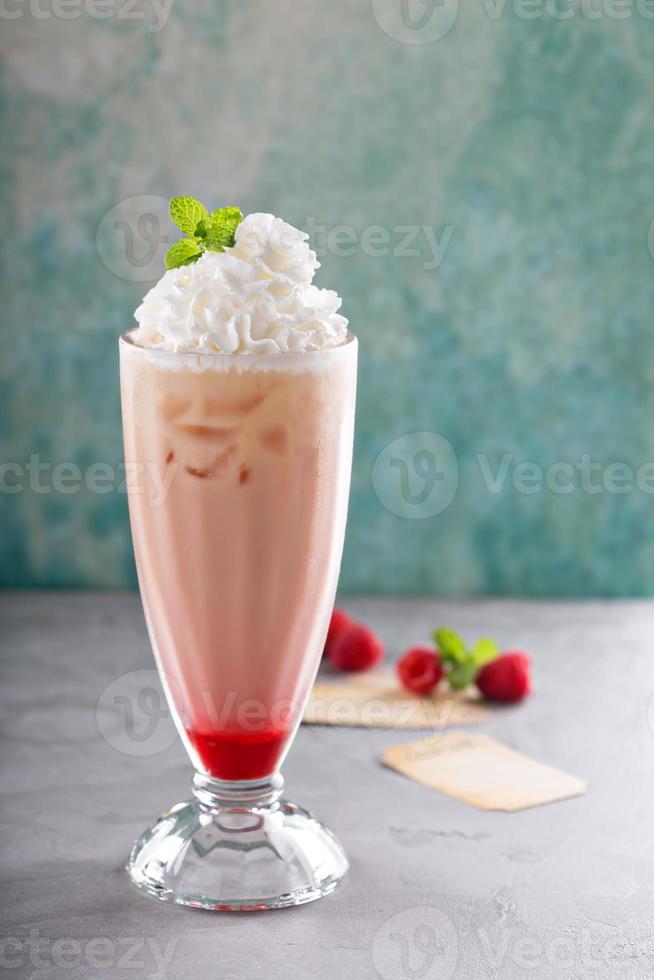 Iced milkshake with raspberry syrup and whipped cream photo