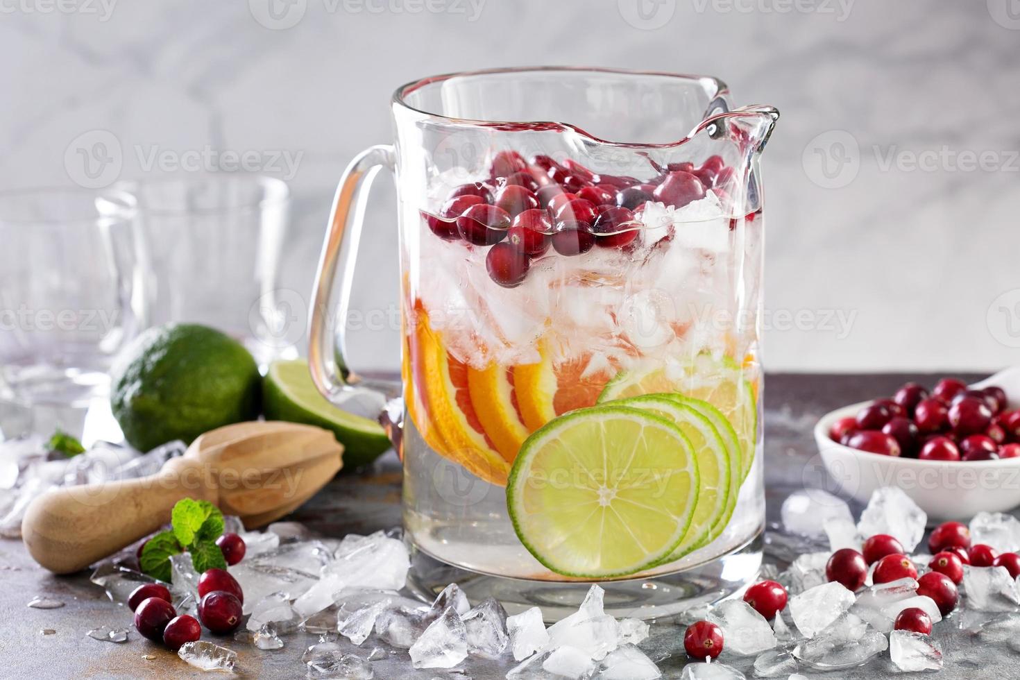 Infused water with citrus fruits and cranberry photo