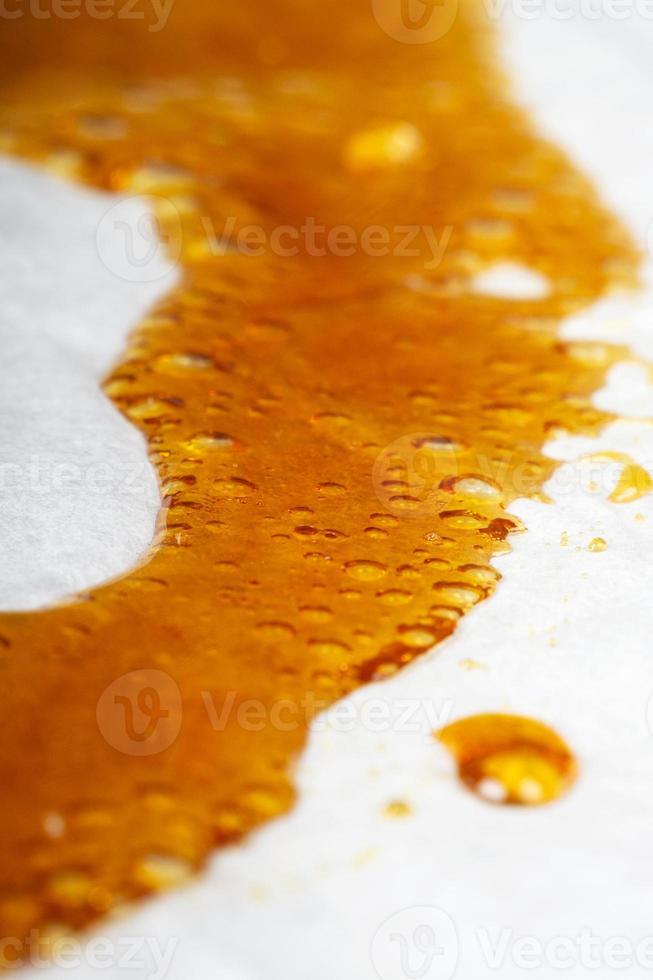 medical cannabis wax running down the paper, orange bubbles resin marijuana photo