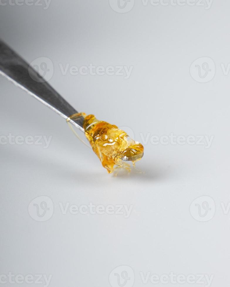 cannabis wax dab concentrate on a stick for smoking essential oils on white background closeup photo