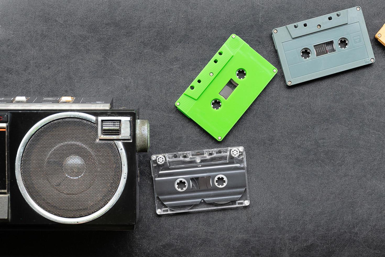 Top view half retro radio and colorful cassette tape on black floor with copy space photo